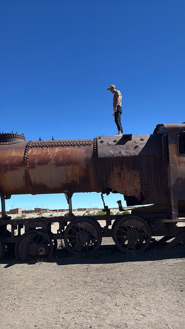 Lucas em cima de uma locomotiva antiga em Uyuni